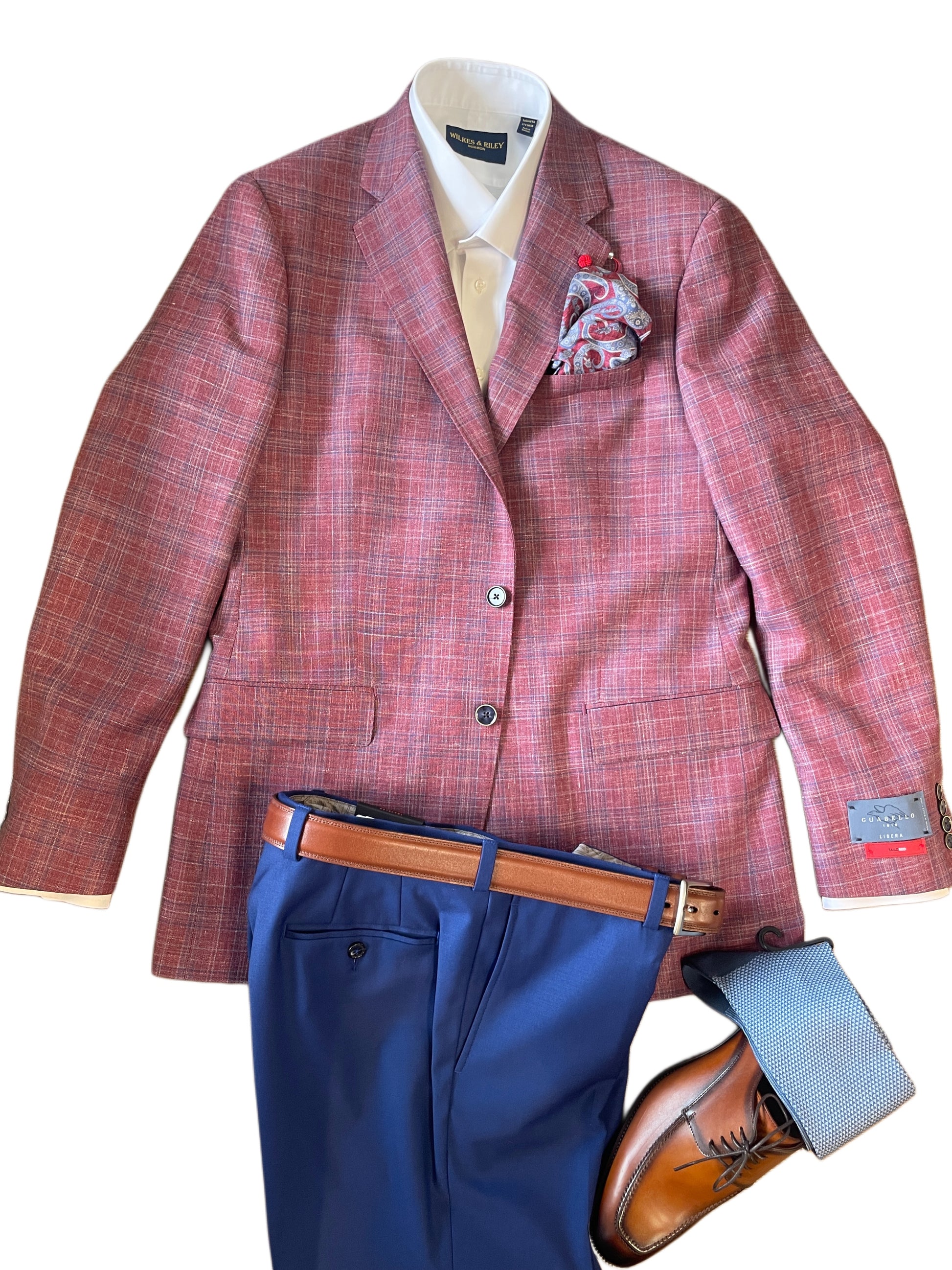 The TailoRed Gilmore Sport Coat 8130538, styled with a pocket square, white dress shirt, blue pants, brown leather belt and dress shoes, plus blue socks, is displayed on a white background.