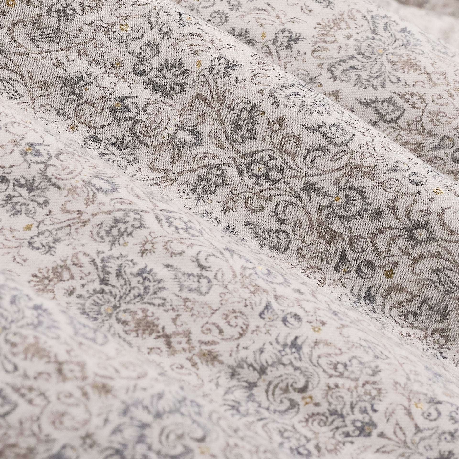 Close-up of the Bugatchi Axel Paisley Sport Shirt KS3132L40S, featuring finely woven fabric with an intricate paisley print in subtle gray and brown hues, highlighted by gentle folds and a soft texture—ideal for an elegant long-sleeve shirt from Bugatchi.