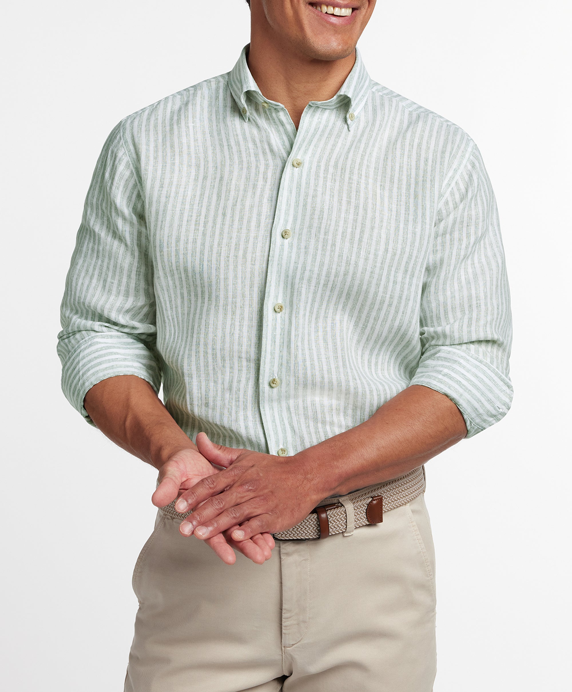 Man wearing a David Donahue Linen Stripe Sport Shirt CBBD12955335 in sage and white stripes with rolled sleeves, paired with beige pants, shown from shoulders to waist.